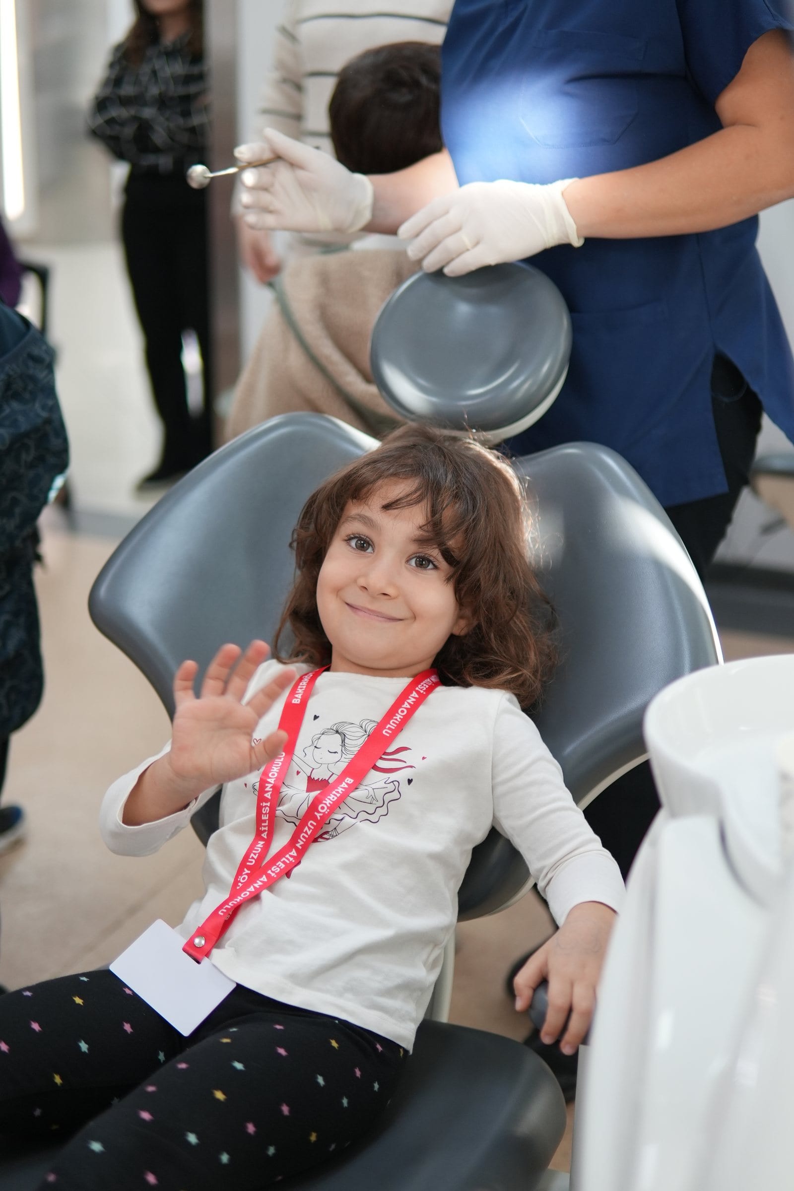 A child smiling and waving in the dental chair at Mosdent